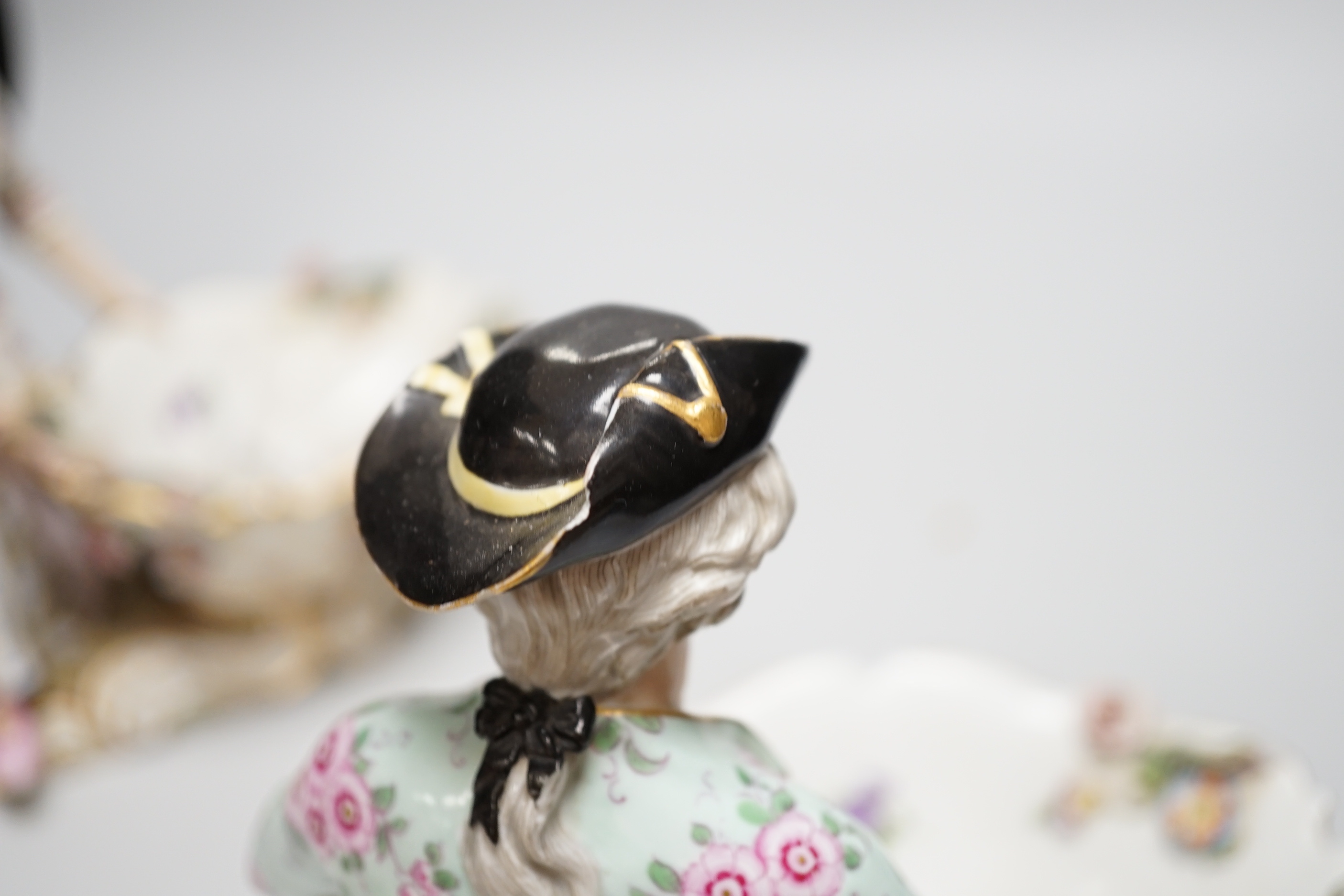 A large pair of Meissen salts in the form of a seated man and a woman in 18th century dress (a.f.), 21cm high